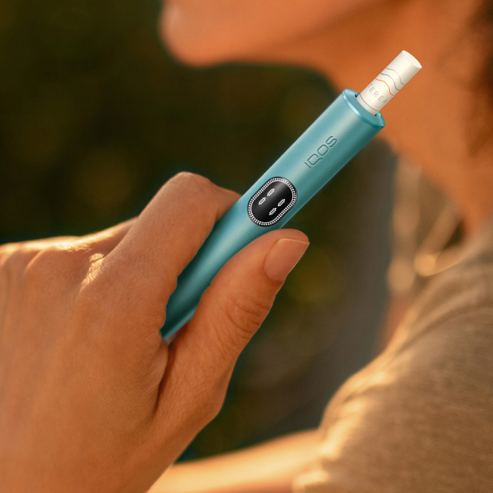 Person holding a breeze blue IQOS Iluma I holder