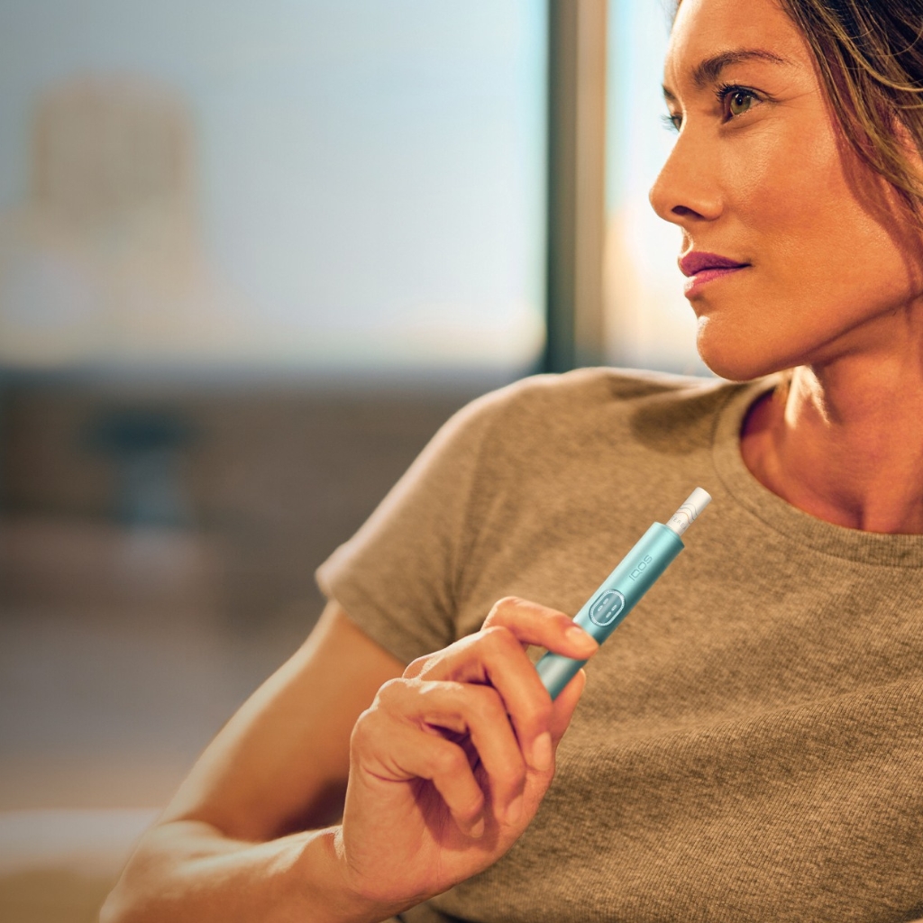 Women holding a Breeze blue IQOS Iluma i Holder