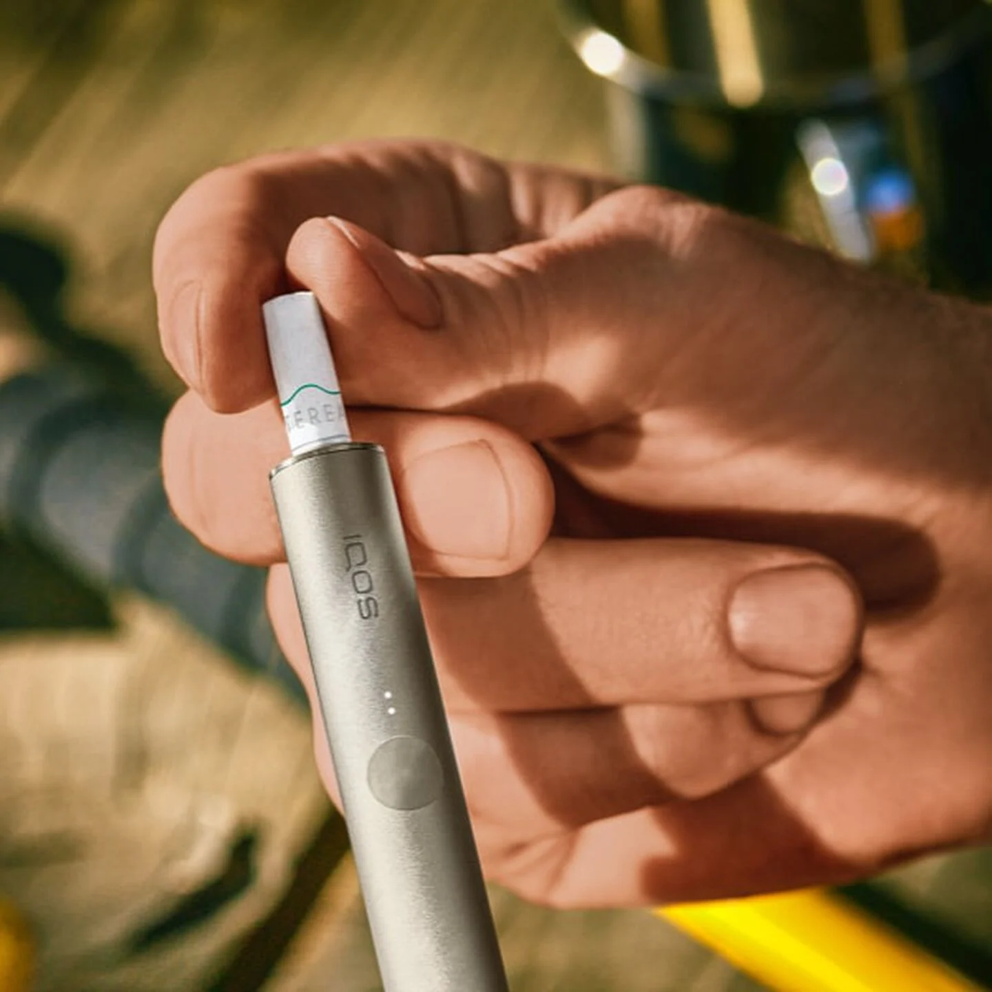 A person places a TEREA stick into an IQOS ILUMA PRIME Holder.