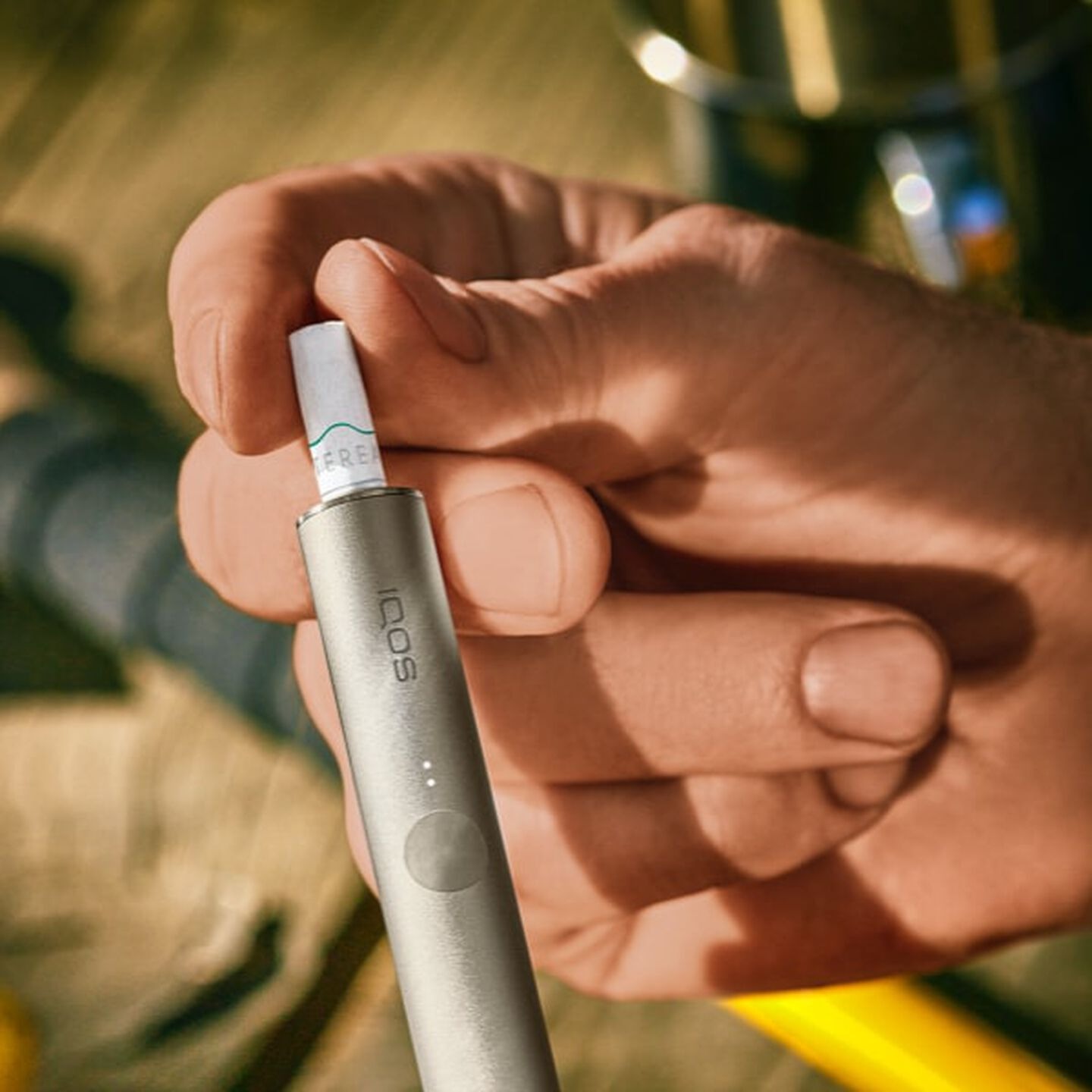 A person placing a TEREA stick into an IQOS ILUMA Holder.