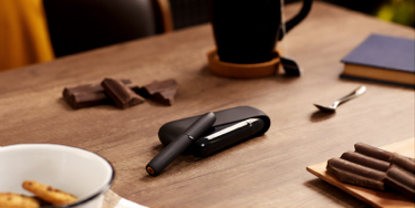 Man with a gold IQOS Duo and a mobile in his hands