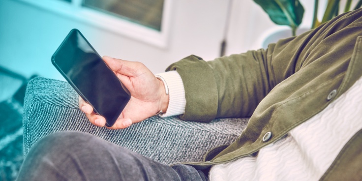A hand holding a smartphone. A hand holding a smartphone.