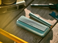 A couple taking a walk; one using an IQOS device.