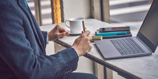 A man sitting on a couch looking at a laptop.