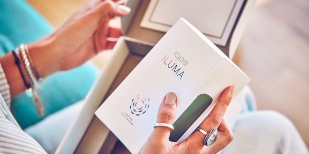 Hands unboxing an IQOS device. Hands unboxing an IQOS device.