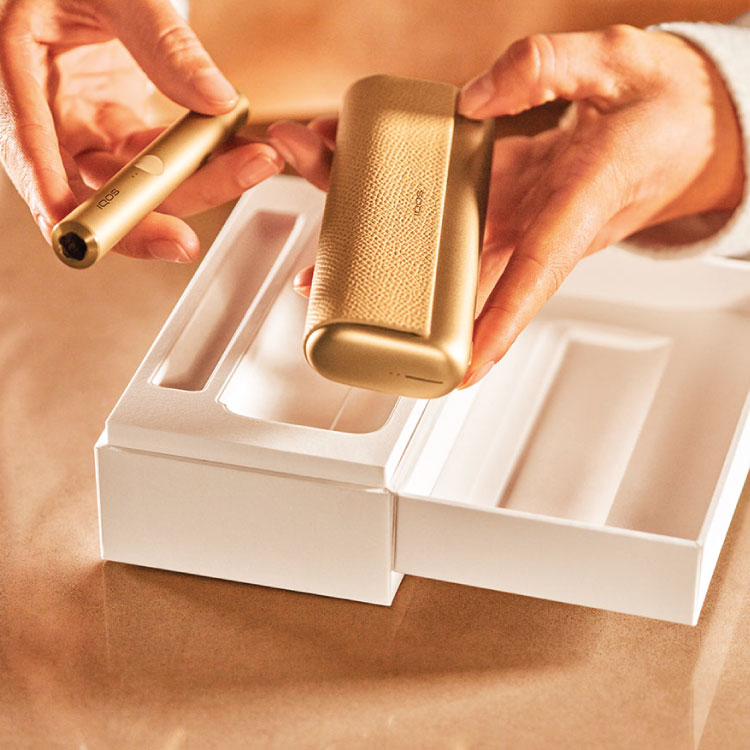 Girl showing a gold IQOS holder