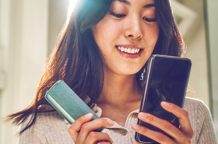 Woman registering IQOS Iluma device on her smartphone Woman registering IQOS Iluma device on her smartphone