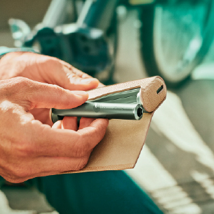 A Jade Green IQOS ILUMA PRIME device being placed into a full wrap.