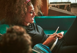 Friends on a sofa, watching television.