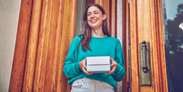 Girl smiling with an IQOS box in her hands Girl smiling with an IQOS box in her hands