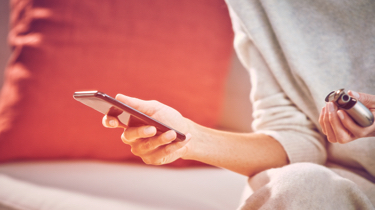 Woman with a golden IQOS holder and charger in her hand