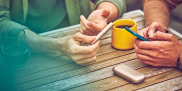 Woman holding her grey IQOS - IQOS charging slowly Woman holding her grey IQOS - IQOS charging slowly