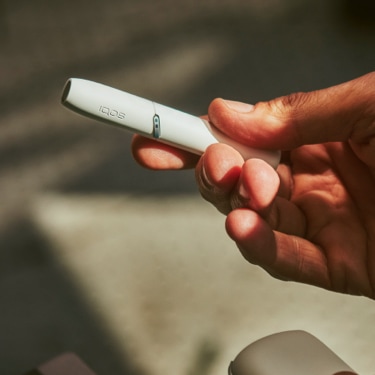 A person holding an IQOS device.