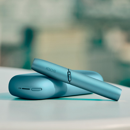 Turquoise IQOS Originals Duo  holder and pocket charger on table. Turquoise IQOS Originals Duo  holder and pocket charger on table.