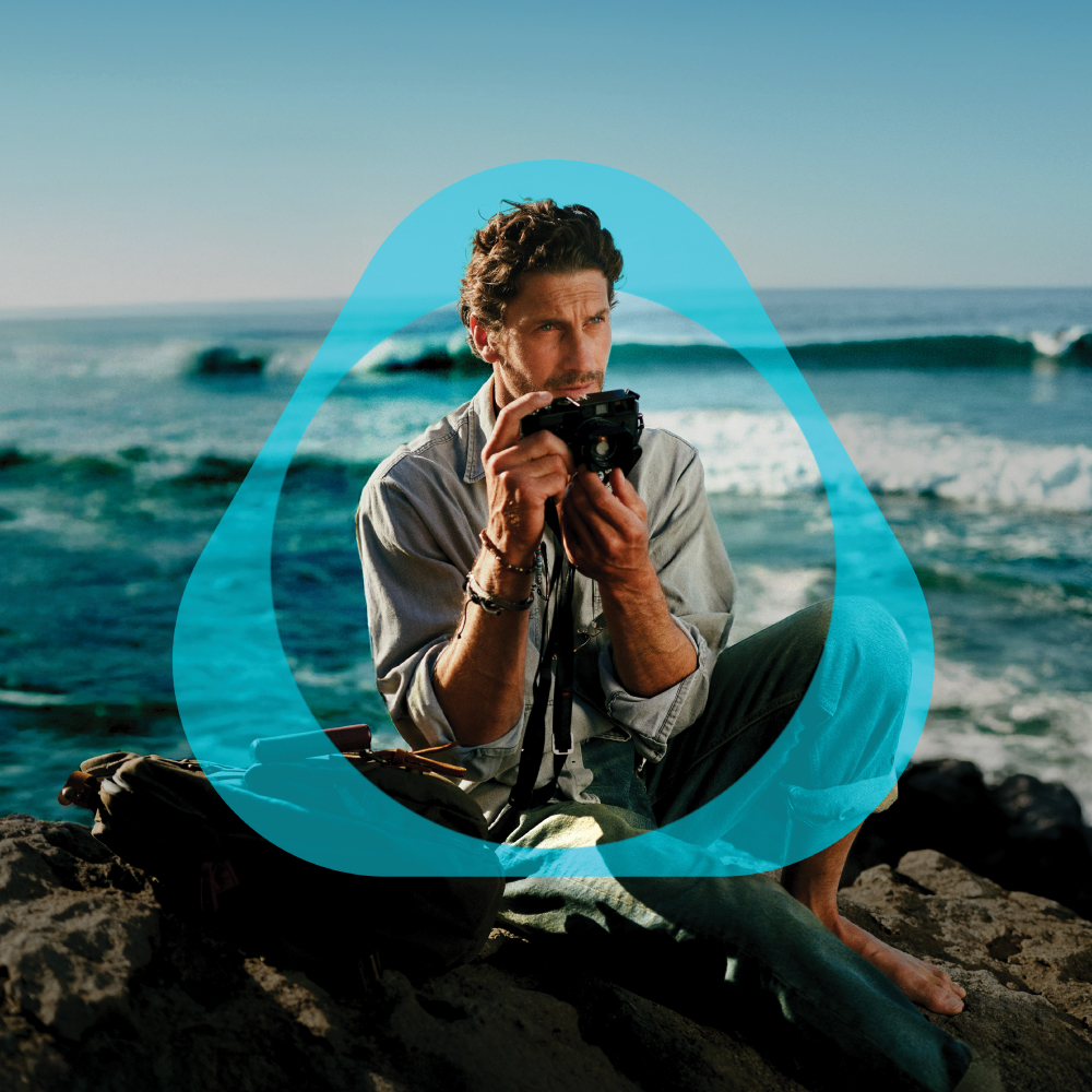 Stay Curious IQOS Banner – A man holding a camera trying new activity